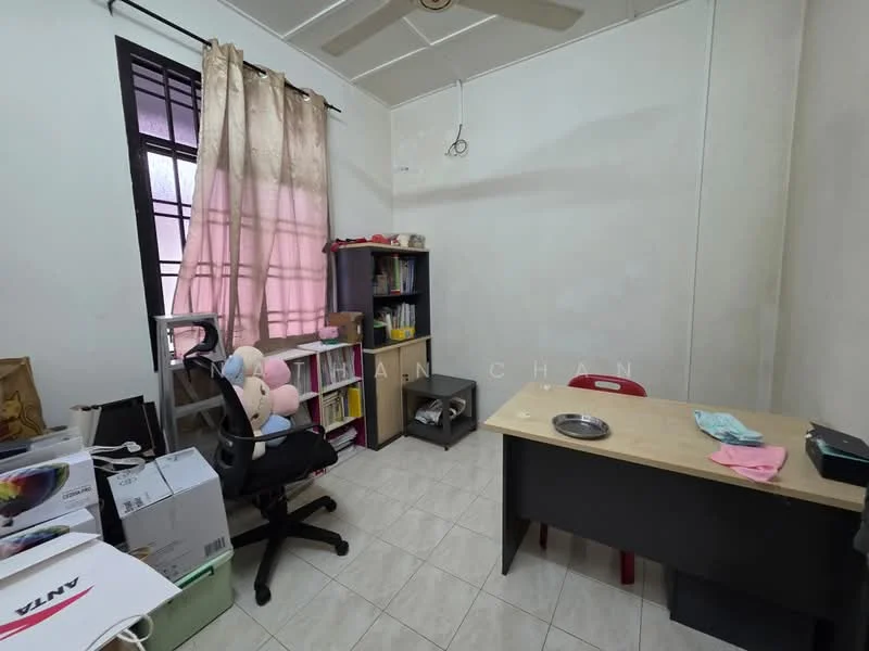 Room features: white painted walls, ceiling fan, tile flooring, window with sheer curtains, bookshelf, desk with black surface, red chair, office chair, storage boxes, decorative items on shelf.