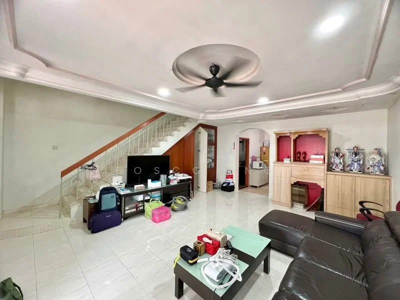 Living features: white painted walls, glossy tile flooring, tray ceiling with ceiling fan, sofa in dark leather, coffee table, TV console, wall-mounted TV, decorative shelving unit, staircase leading to upper floor, various bags and items on the floor; style: modern.