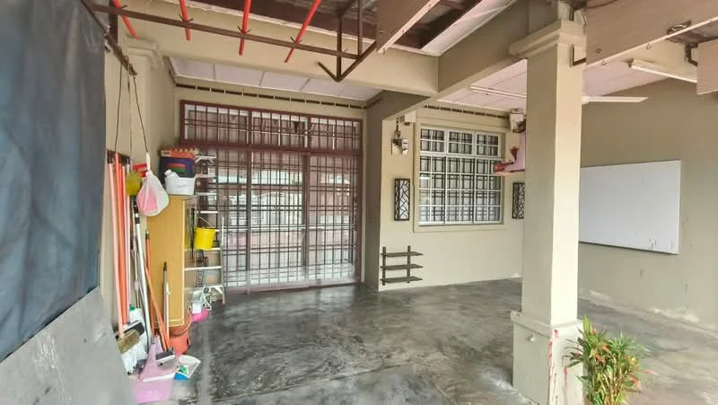 Room features: concrete flooring, grey painted walls, metal grilles on windows, wooden door with metal grilles, open space layout, exposed ceiling beams, whiteboard on wall, storage shelves with various items, potted plant; style: modern.