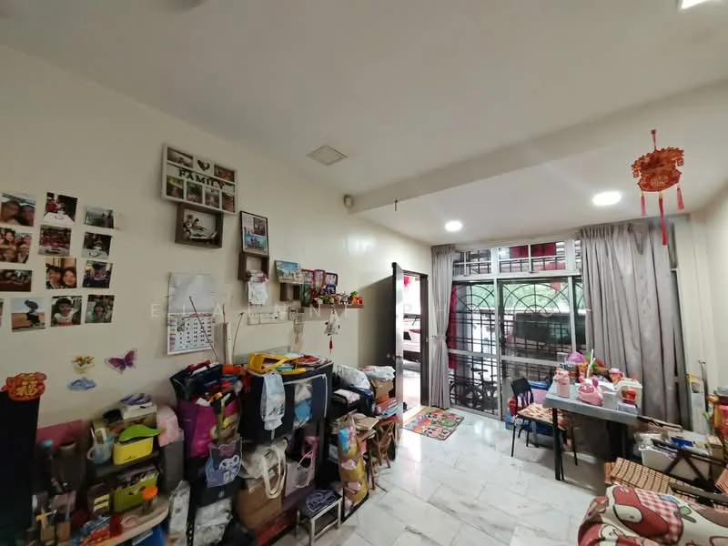 Room features: white painted walls, marble flooring, floor-to-ceiling windows, curtains, decorative wall with family photos, shelves with various items, cluttered storage area, small dining table, colorful area rug; style: modern.