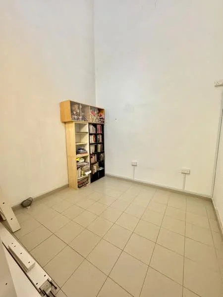 Room features: white painted walls, tile flooring, built-in bookshelf, light switch on wall, power outlets on wall.