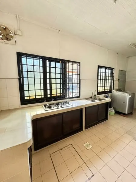 Kitchen features: L-shaped countertop, white tiled backsplash, double-bowl stainless-steel sink, chrome pull-down faucet, 4-burner gas hob, black cabinetry with glass fronts, tile flooring, two large windows with grid pattern, washing machine, light fixture on ceiling.