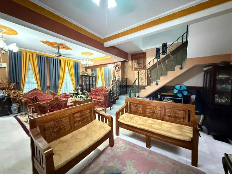 Living features: wooden seating with upholstered cushions, area rug with floral pattern, cream painted walls, gold crown moulding, chandelier, ceiling fan with light, large windows with yellow curtains, decorative wall art, staircase with wrought iron railing, wooden display cabinet, green decorative plants; style: traditional.