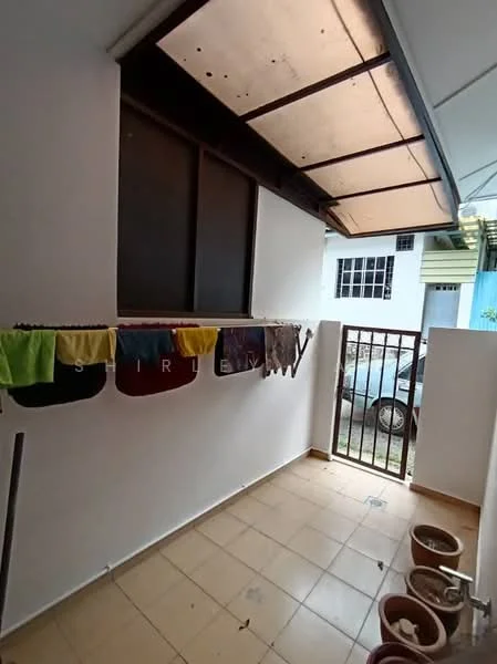 Room features: white painted walls, tiled flooring, clothes drying rack, security grille, window with glass panes, outdoor view, potted plants, overhead roof.