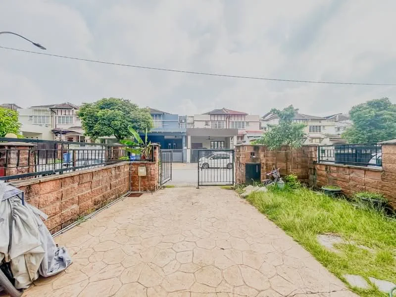 Exterior type: linked terrace house; features: stone-paved walkway, manicured lawn, fenced perimeter, gate at entrance, surrounding greenery, two-storey houses in background, concrete wall, driveway, visible street in front; style: modern.
