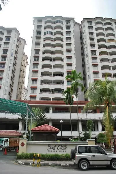 Exterior type: mid-rise condominium; features: white painted facade, recessed balconies, palm trees, manicured lawn, covered parking, entrance gate with signage, multiple storeys, landscaped garden; style: modern.