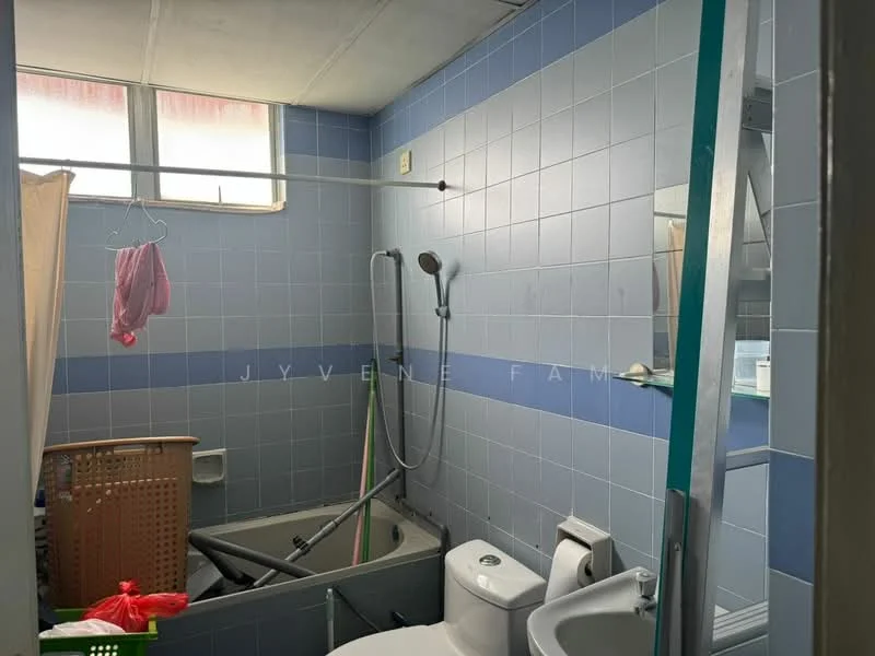 Bathroom features: bathtub, shower head, toilet, sink, blue tiled walls, grey tiled flooring, window, shower curtain rod, clothes drying rack, basket, mirror.