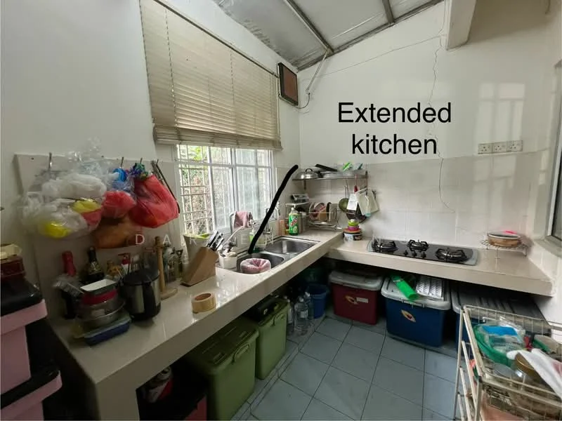 Kitchen features: extended kitchen layout, single-bowl stainless-steel sink, chrome pull-down faucet, 2-burner gas hob, white tiled backsplash, light-colored countertop, green storage bins, various cooking utensils, window with blinds, blue tiled flooring.