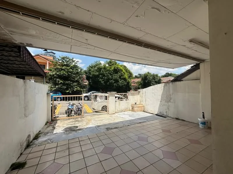 Exterior features: paved flooring, white painted walls, open space, surrounded by greenery, parking area visible, fenced perimeter, gate access.