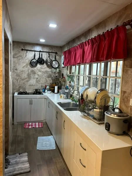 Kitchen features: white cabinetry, marble countertop, stainless-steel sink, chrome pull-down faucet, 4-burner gas hob, built-in rice cooker, hanging pots and pans, window with grid design, red curtains, tile backsplash, wood-look tile flooring, dish rack with plates, kitchen towels, two dish mats; style: modern.