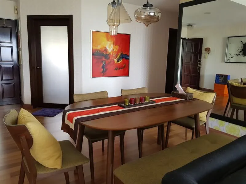 Dining features: wooden dining table, 6-seater dining table, upholstered dining chairs with yellow cushions, decorative table runner, candles on table, framed artwork on wall, light fixture with glass shade, wooden flooring, wall with subtle pattern, mirror reflecting room, doorway leading to another room, wall-mounted artwork; style: modern.