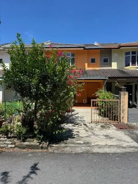 Exterior type: linked terrace house; features: orange and yellow painted facade, single-storey, paved driveway, manicured garden with flowering plants, fenced front yard, roof with tiles, front porch, surrounded by greenery; style: modern.