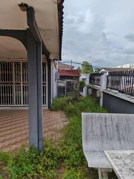 Exterior type: linked terrace house; features: paved walkway, fenced perimeter, manicured lawn, overgrown grass, outdoor seating area, gutter system, roof overhang, brick exterior, single-storey, surrounded by greenery; style: modern.