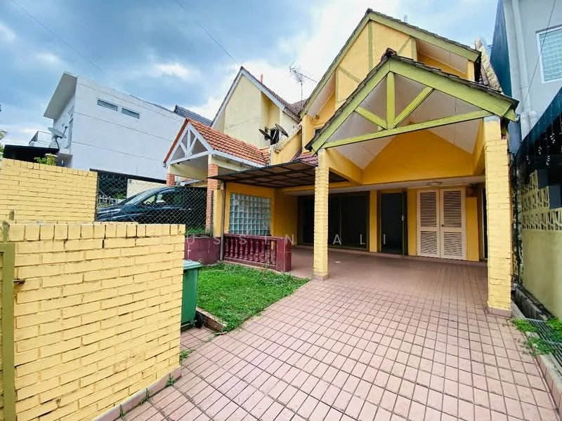 Exterior type: semi-detached house; features: yellow painted facade, pitched roof, covered car porch, brick paving, manicured lawn, fenced yard, windows with shutters, exposed beams at porch, garden area, two-storey structure; style: traditional.