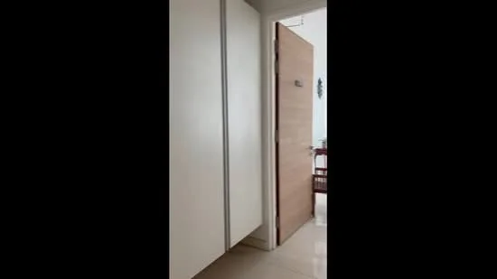 Room features: white cabinetry, wooden door, tile flooring, light-colored walls, door handle, door sign, visible furniture in background; style: modern.