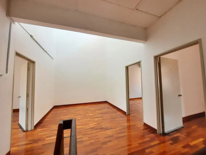 Room features: wooden flooring, white painted walls, high ceiling, two doorways, one door with handle, natural light from above, neutral color scheme, no visible furniture; style: minimalist.