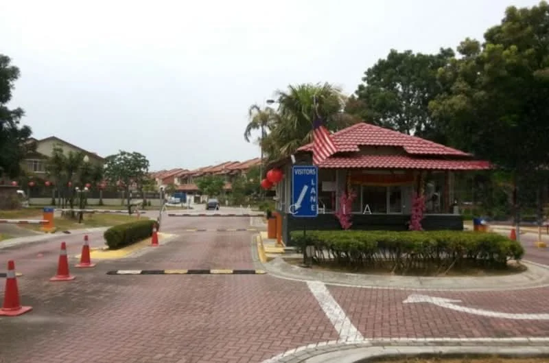 Exterior type: gated community entrance; features: guard house at entrance, red tiled roof, paved driveway, landscaped garden with shrubs, traffic cones for direction, flagpole with flag, visitor parking area, surrounding residential buildings, palm trees, street lighting; style: modern.