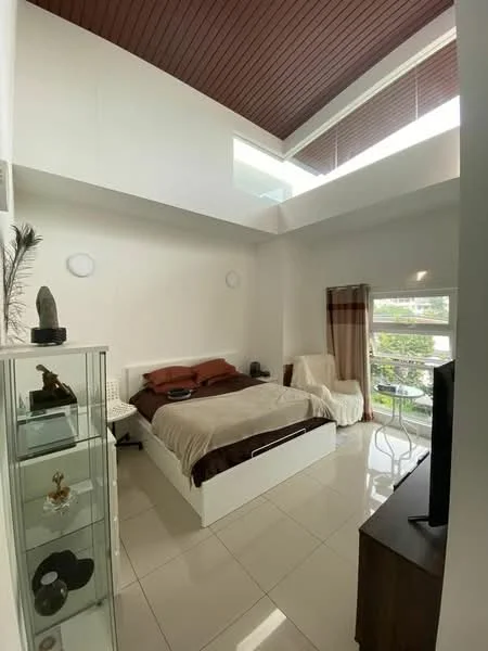 Bedroom features: king-size bed with brown bedding, white bed frame, white walls, brown wooden ceiling, large windows with sheer curtains, ceramic tile flooring, TV on wooden cabinet, armchair, glass display cabinet, decorative sculpture, small dining table with chairs; style: modern; view: garden.