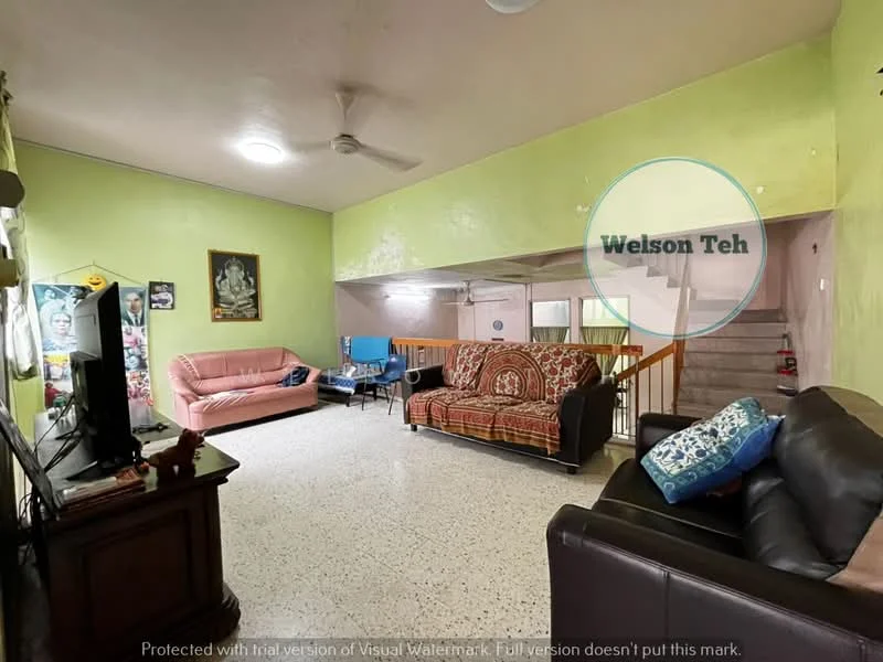 Living features: green painted walls, speckled tile flooring, 5-blade ceiling fan, sofa in black leather, sofa in pink fabric, sofa with patterned upholstery, wooden TV cabinet, framed artwork on wall, wooden railing, decorative throw pillows.