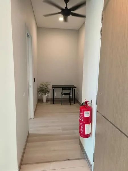 Room features: light wood flooring, white painted walls, ceiling fan, small table with chair, fire extinguisher mounted on wall, door frame, door to adjacent room; style: modern.