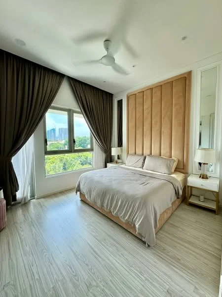 Bedroom features: king-size bed with beige upholstered headboard, light grey bedding, two bedside tables with lamps, floor-to-ceiling window, curtains in dark brown, light wood flooring, ceiling fan, decorative wall paneling behind the bed, mirror on the wardrobe, view of greenery outside; style: modern; view: garden.