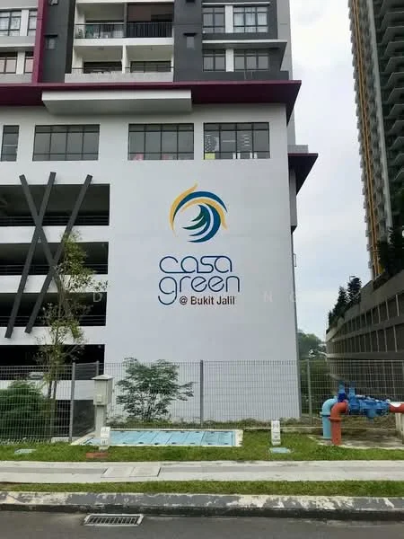 Exterior type: high-rise condominium; features: white painted facade, balconies with glass railings, signage with logo, landscaped area with grass, fenced perimeter, fire hydrant visible, parking structure visible, surrounding greenery; style: modern.