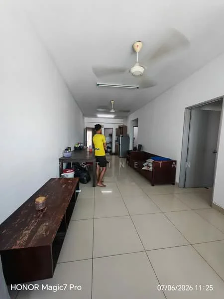 Living features: white painted walls, tile flooring, ceiling fan, sofa in dark brown, wooden coffee table, open layout, kitchen area visible, refrigerator visible, dining area visible, light from ceiling fixture.