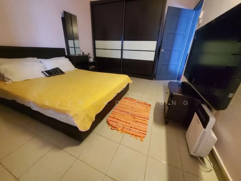 Bedroom features: queen-size bed with yellow bedspread, black upholstered headboard, two white pillows, wooden wardrobe with sliding doors, large flat-screen TV on stand, area rug with orange and yellow stripes, wall-mounted air conditioning unit, tiled flooring, light pink painted walls.