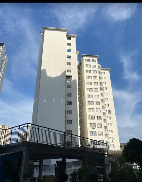 Exterior type: mid-rise condominium; features: cream painted facade, multiple storeys, balconies on upper floors, windows with grills, parking area underneath, surrounding greenery, clear blue sky, shadow cast on the building; style: modern.