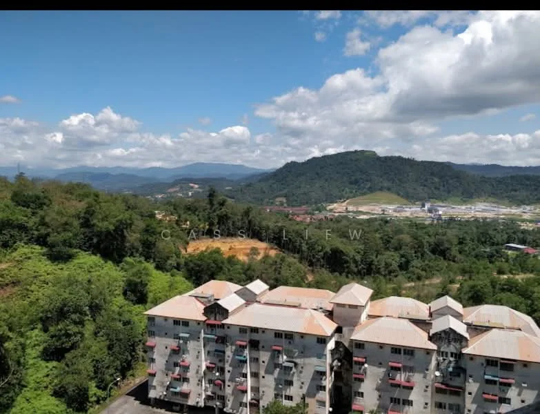 Exterior type: low-rise apartment block; features: grey painted facade, flat roof, approximately 3-storey, surrounded by greenery, mountain view in background, clear blue sky, visible parking area; style: modern.