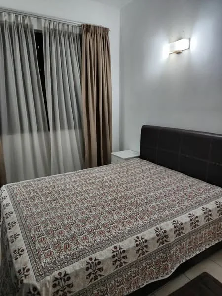 Bedroom features: queen-size bed, upholstered headboard, decorative bedspread with floral pattern, nightstand, table lamp, floor-to-ceiling window, sheer curtains, brown blackout curtains, wall-mounted light fixture, neutral wall colour, tile flooring; style: modern.
