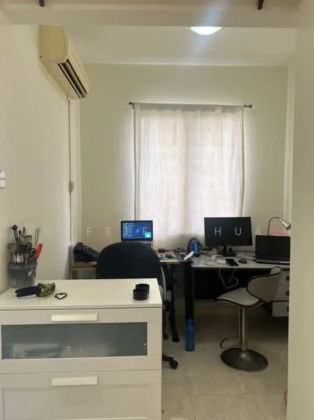 Study features: light-colored painted walls, tile flooring, 1 wall-mounted split AC, window with sheer curtains, desk with computer monitor, desk with laptop, black office chair, white storage cabinet, pen holder, water bottle, decorative items on desk; style: modern.