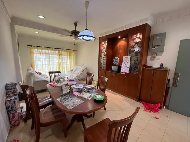 Dining features: wood dining table, 6 wooden dining chairs, ceiling fan with light, white painted walls, tile flooring, large windows with sheer curtains, built-in wooden cabinet, television on cabinet, decorative wall paneling, various papers and magazines on table, sofa in white fabric, light fixture with blue glass shade; style: traditional.