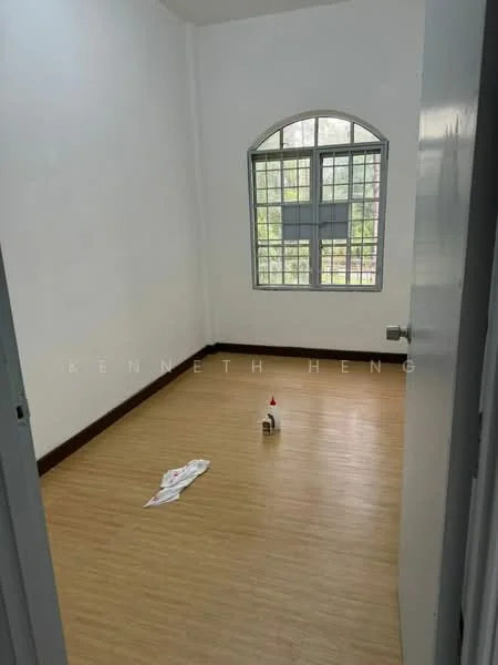 Room features: white painted walls, laminate flooring, large arched window, window with grid pattern, light-colored skirting, cleaning supplies on floor.