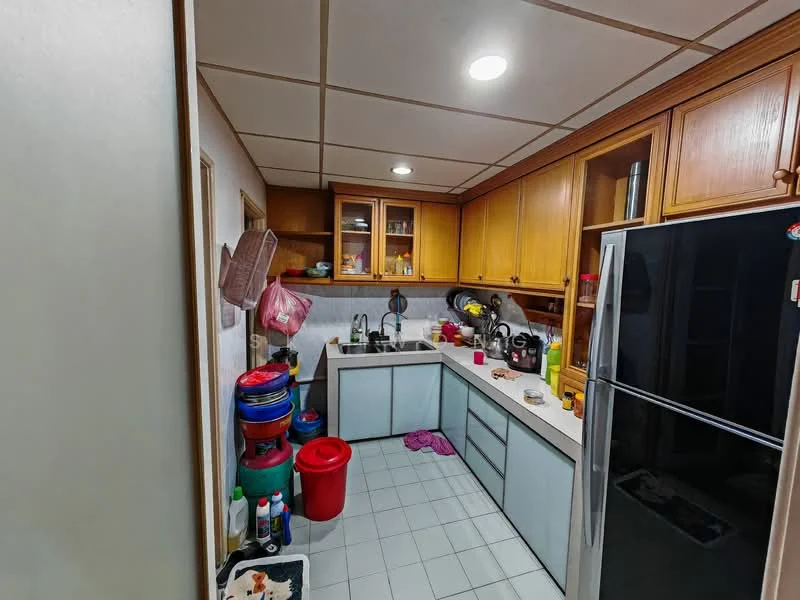 Kitchen features: light wood cabinetry, grey laminate lower cabinets, white countertop, single-bowl stainless-steel sink, chrome pull-down faucet, built-in refrigerator, ceramic tile flooring, recessed ceiling lights, open shelving, various plastic containers, cleaning supplies, colorful plastic buckets, dish drying rack.