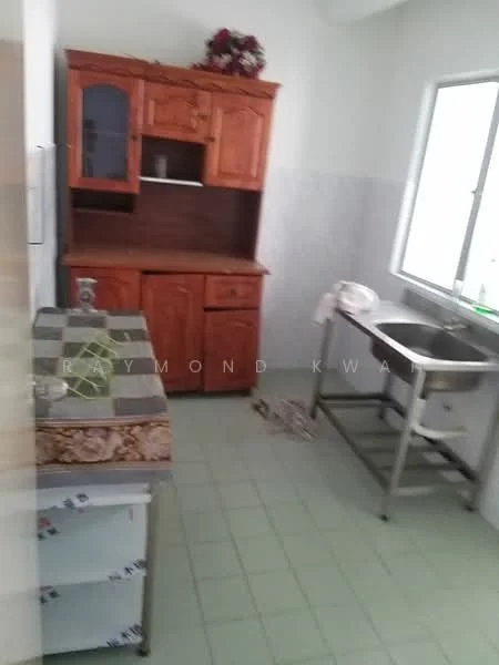 Kitchen features: wooden cabinetry with glass doors, stainless-steel sink, countertop with decorative edge, green tiled flooring, window with natural light, wall-mounted shelves, decorative items on top of cabinetry.