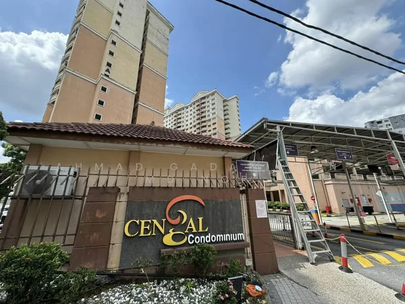 Exterior type: high-rise condominium; features: cream painted facade, signage with 'CENgAL Condominium', manicured flower beds, covered parking area, multiple storeys visible, surrounded by greenery, entrance gate, security features visible; style: modern.