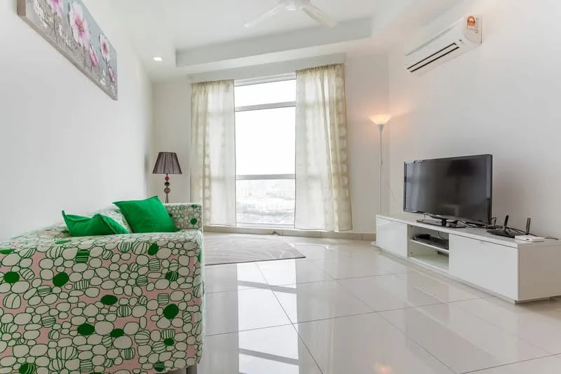 Living features: green floral patterned sofa, white tiled flooring, floor-to-ceiling windows, sheer curtains, wall-mounted TV, white TV console, lamp with shade, ceiling fan with light, recessed lighting; style: modern; view: city.
