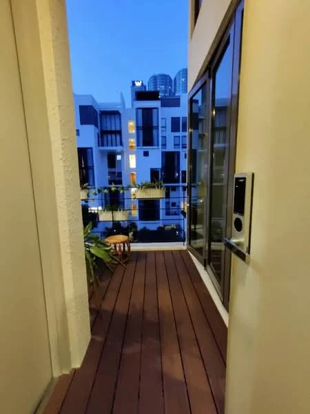 Room features: wooden decking, glass railing, potted plants, evening lighting, city skyline view; style: modern; view: city.