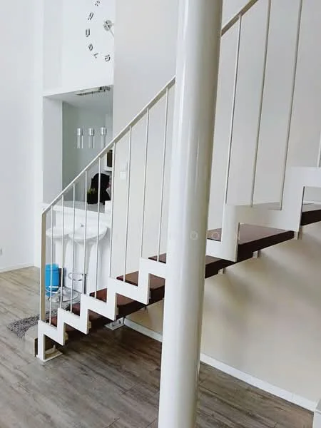 Room features: white painted walls, wooden flooring, staircase with white railing, open space, clock on wall, decorative wall sconce, grey area rug, column support; style: modern.