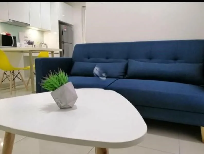 Living features: blue fabric sofa, white coffee table with wooden legs, decorative potted plant, white walls, glossy tile flooring, recessed downlights, open-plan layout, kitchen area visible in background, microwave visible, fridge visible, yellow dining chairs visible; style: modern.