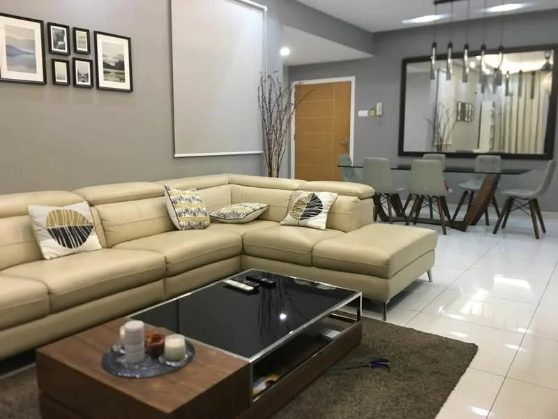 Living features: L-shape sectional sofa in beige, decorative cushions with geometric patterns, coffee table with glass top and wooden base, area rug with neutral color, wall-mounted artwork in frames, recessed ceiling lights, pendant lighting above dining area, white tiled flooring, grey painted walls, large mirror reflecting the dining area, dining table with grey chairs; style: modern.
