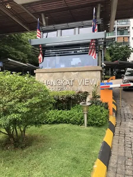 Exterior type: high-rise condominium; features: main entrance gate, landscaped garden, manicured lawn, flag poles with Malaysian flags, stone-clad entrance, parking area, security barrier, surrounded by greenery; style: modern.