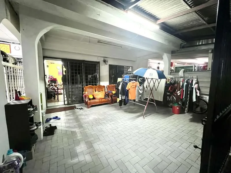 Exterior features: paved flooring, covered area, clothes drying rack, outdoor seating with wooden sofa, umbrella, open space, surrounding walls, entrance to indoor area.