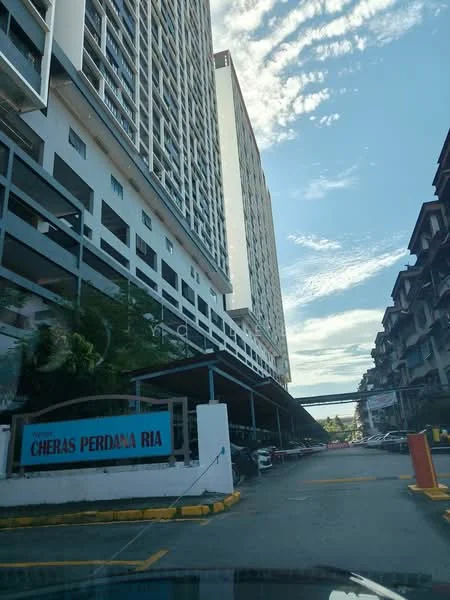Exterior type: high-rise condominium; features: multi-storey car park, covered parking, driveway with interlocking pavers, glass curtain wall, white painted facade, surrounded by mature greenery, adjacent to highway; style: modern.