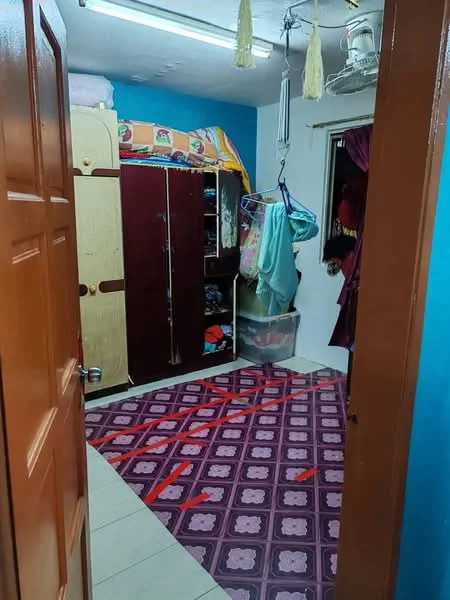 Room features: blue painted walls, tile flooring, wooden door, built-in wardrobe with sliding doors, hanging clothes rack, window with curtain, ceiling fan, area rug with geometric pattern, plastic storage container.