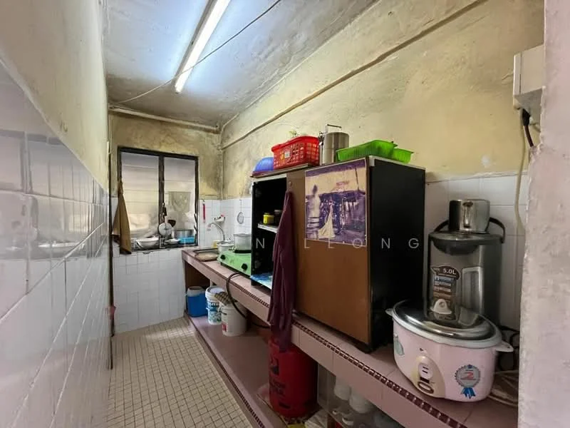 Kitchen features: white tiled walls, grey tiled flooring, wooden countertop, black refrigerator, blender, rice cooker, plastic storage containers, sink, window with metal frame, multiple shelves, kitchen utensils, baskets for storage.
