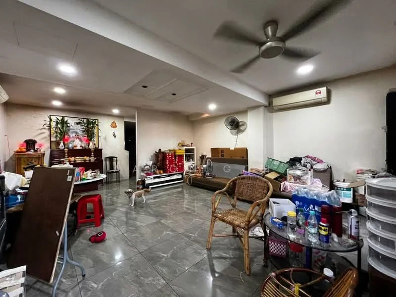Room features: grey marble tile flooring, white painted walls, ceiling fan, recessed LED downlights, wall-mounted air conditioning unit, wooden furniture, plastic storage containers, various household items scattered, decorative plants, rattan chair, small dog visible.