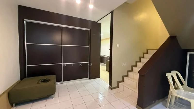 Room features: white tiled flooring, cream painted walls, dark wood sliding door, staircase with brown railing, recessed ceiling lights, green fabric sofa, plastic chair, open space layout; style: modern.