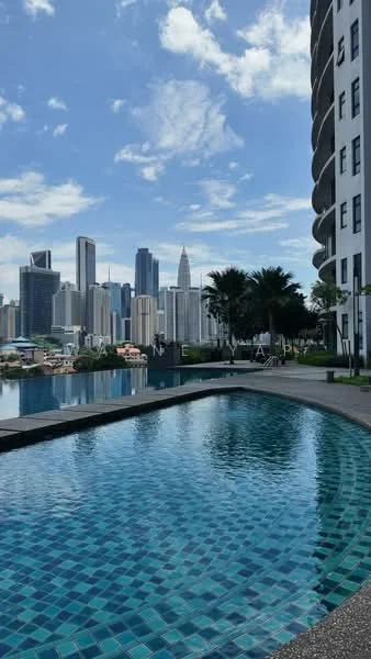 Exterior type: high-rise condominium; features: infinity pool, pool deck with loungers, city skyline view, tiled pool surface, landscaped garden area, palm trees, modern architectural design, glass curtain wall facade; style: modern.